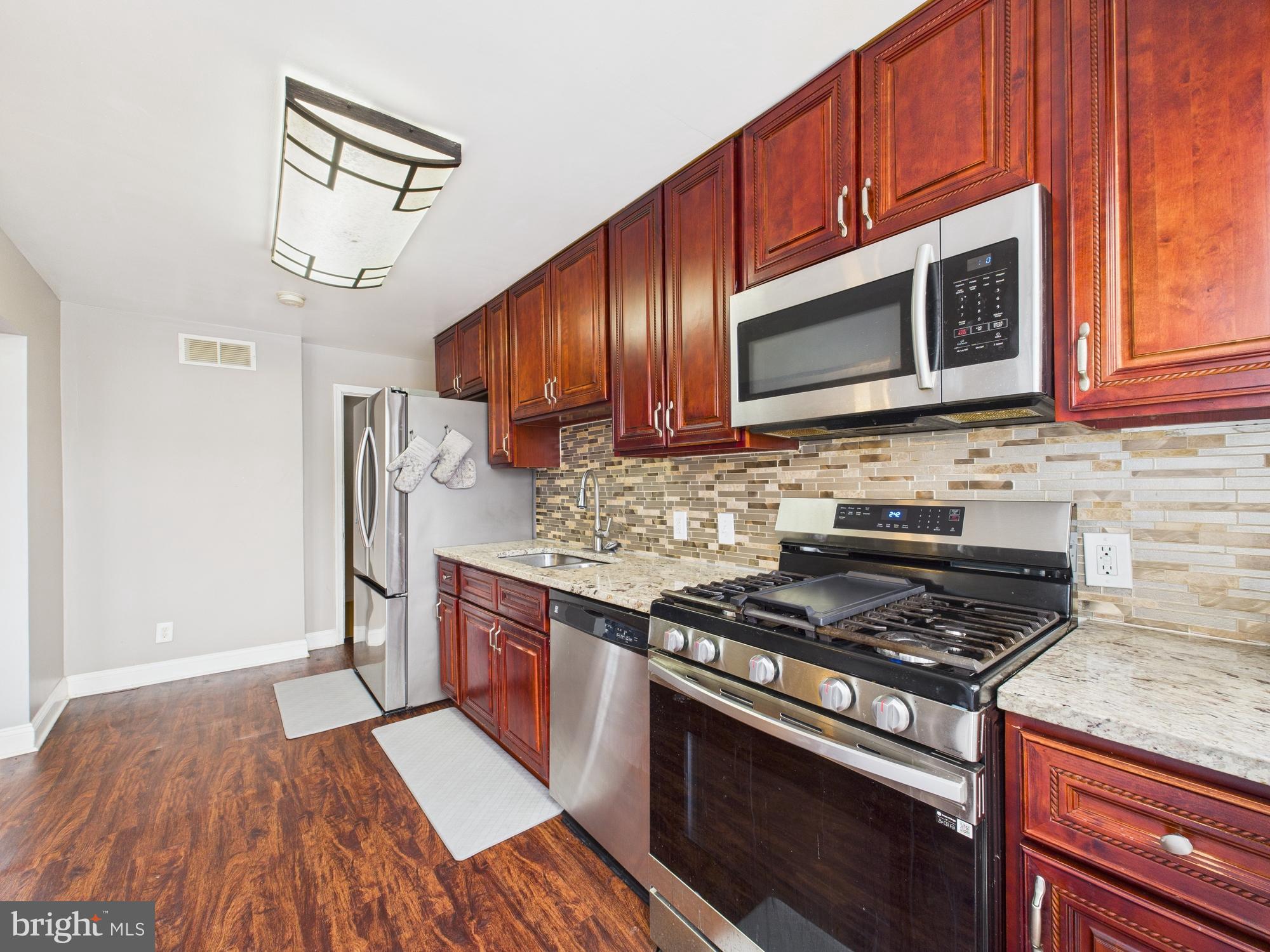 1551 Langford Road Baltimore, MD 21207 - Photo 17 of 52 a kitchen with stainless steel appliances granite countertop a stove microwave and cabinets