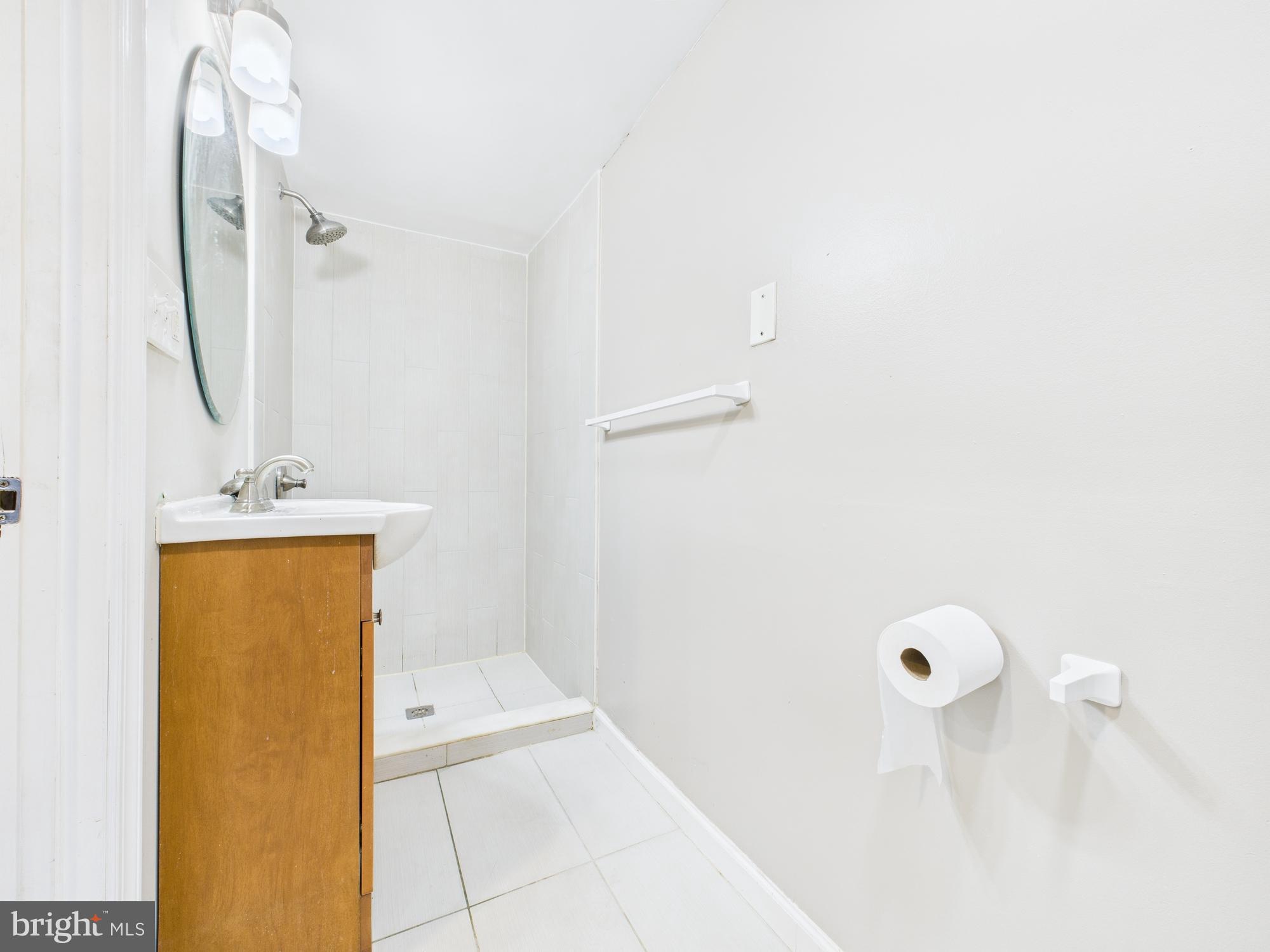 1551 Langford Road Baltimore, MD 21207 - Photo 31 of 52 a bathroom with a sink a mirror and shower
