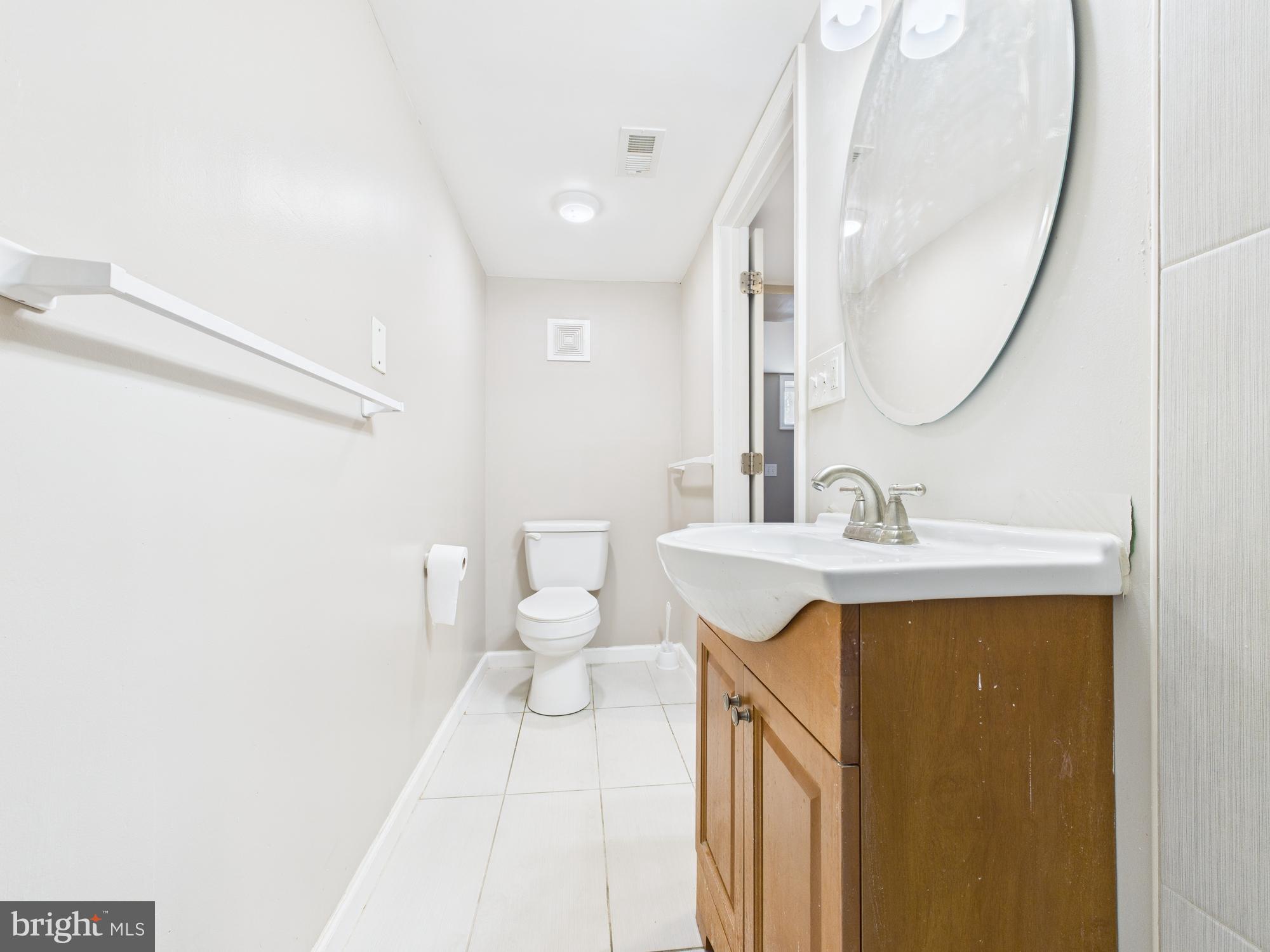 1551 Langford Road Baltimore, MD 21207 - Photo 32 of 52 a bathroom with a sink a toilet and a mirror