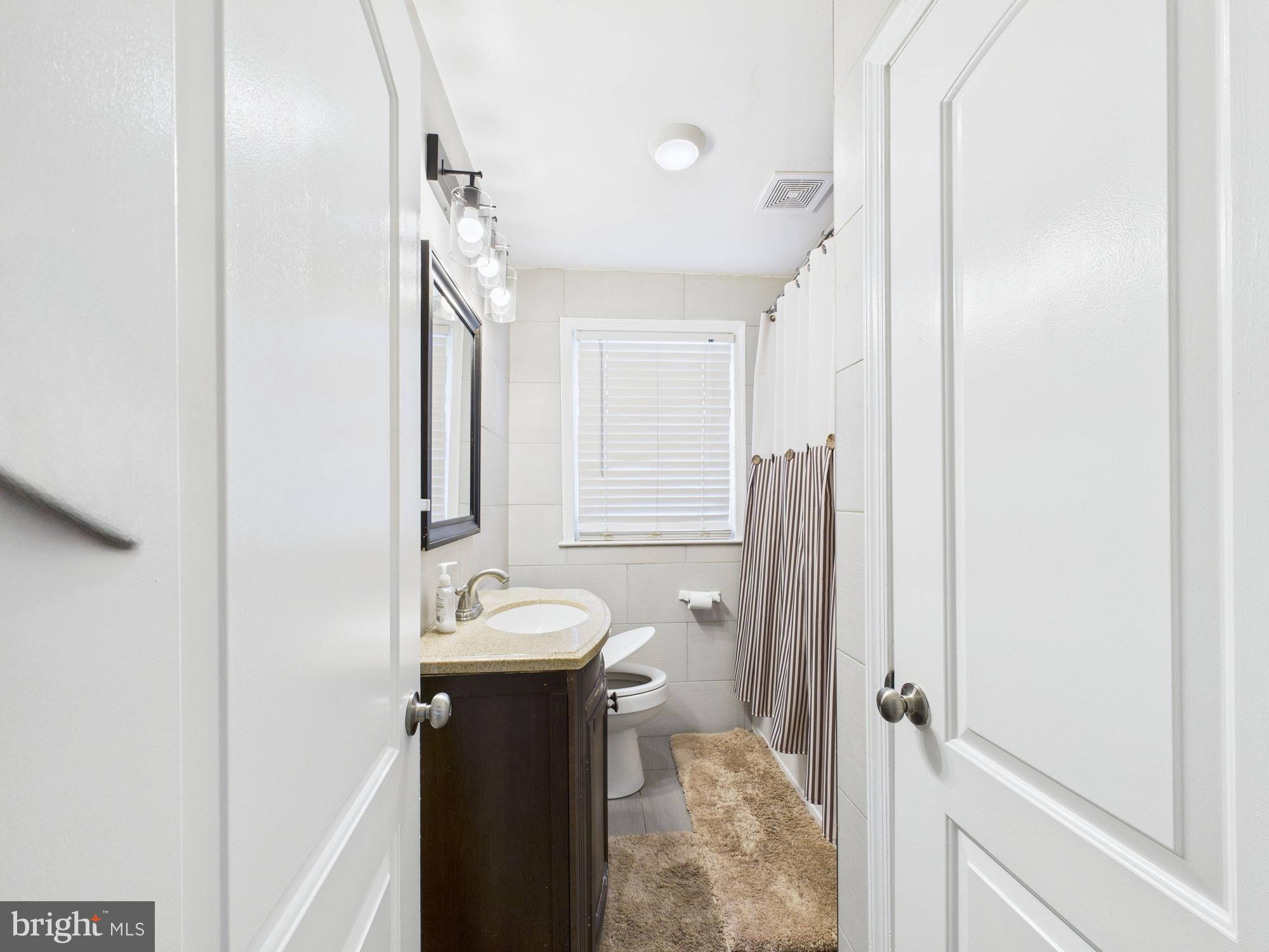 1551 Langford Road Baltimore, MD 21207 - Photo 48 of 52 a bathroom with a sink mirror and toilet