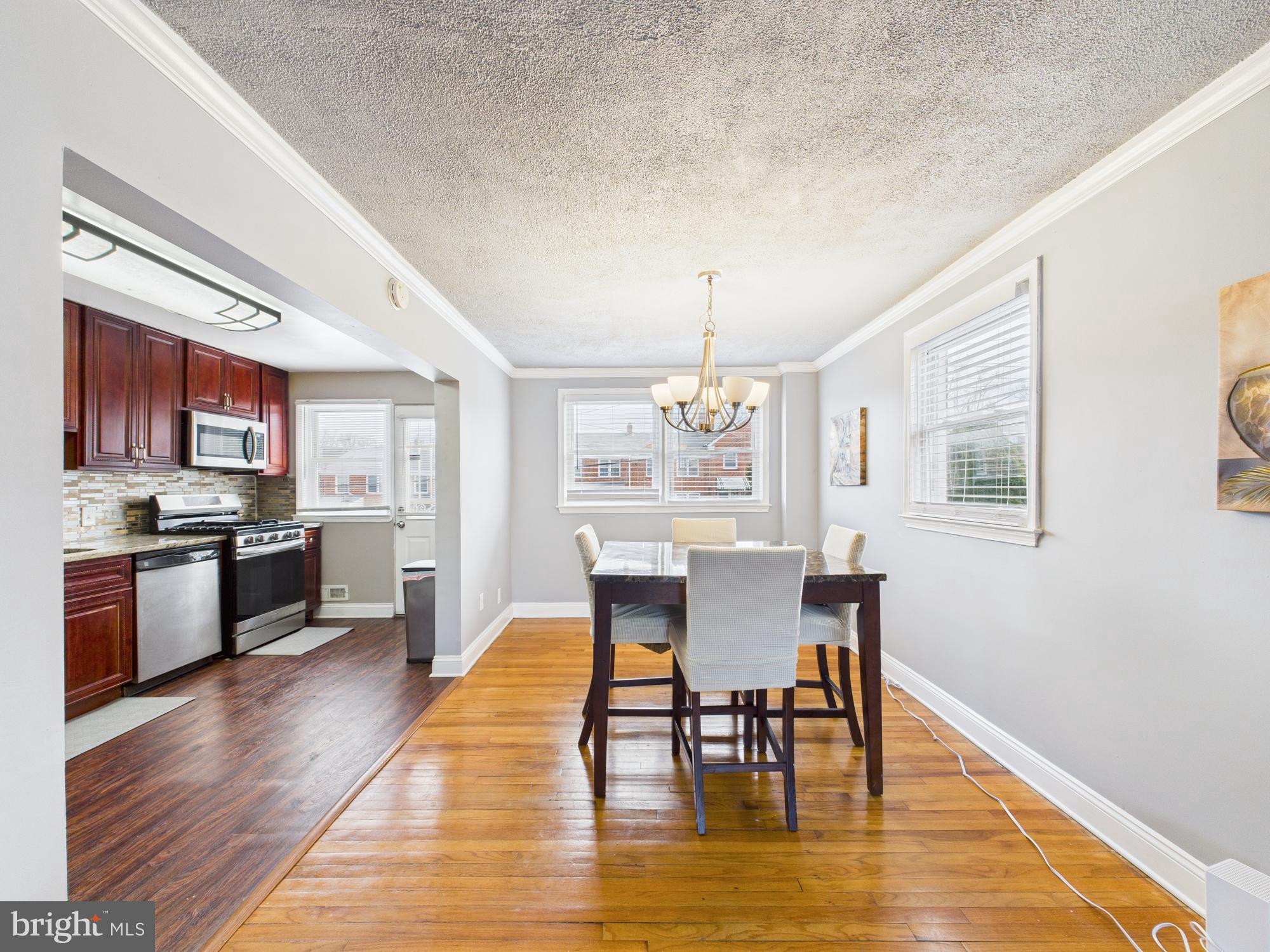 1551 Langford Road Baltimore, MD 21207 - Photo 6 of 52 a view of a dining room with furniture a chandelier and wooden floor