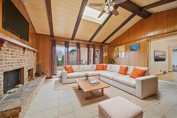 a living room with furniture a fireplace and a flat screen tv