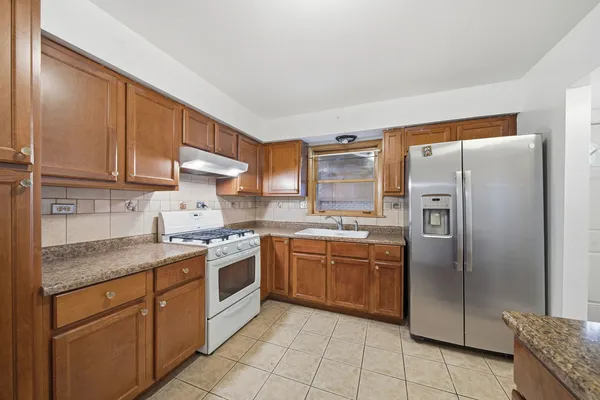 a kitchen with stainless steel appliances granite countertop a refrigerator sink and cabinets