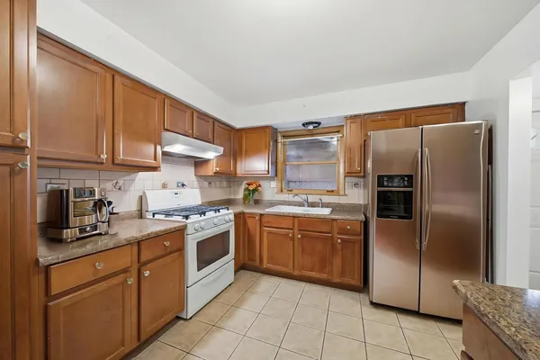 a kitchen with stainless steel appliances granite countertop a refrigerator sink and cabinets
