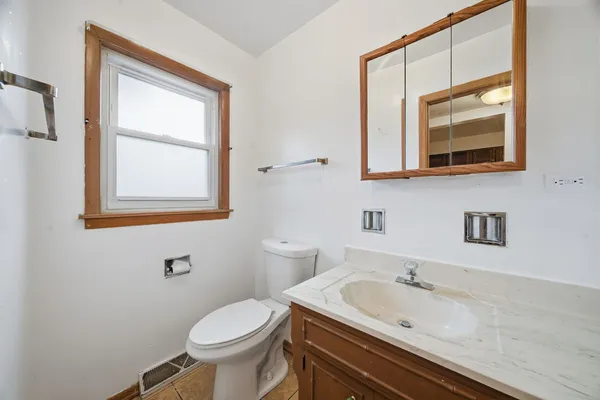 a bathroom with a toilet sink vanity and mirror