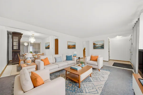 a living room with furniture a table and a large window