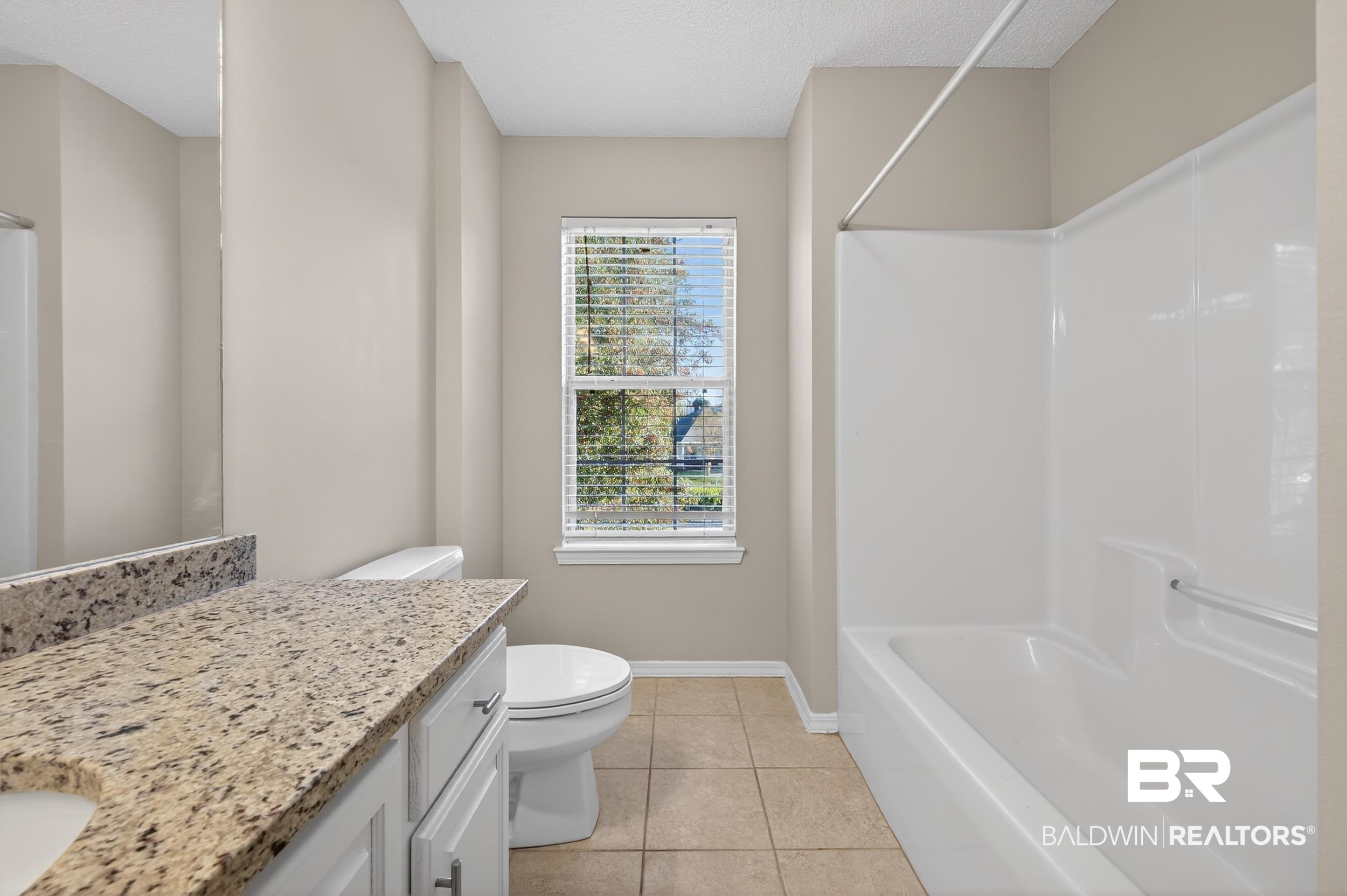 7050 Highpointe Place West Daphne, AL 36527 - Photo 55 of 66 Bathroom with vanity, light tile patterned flooring, shower / washtub combination, and a textured ceiling
