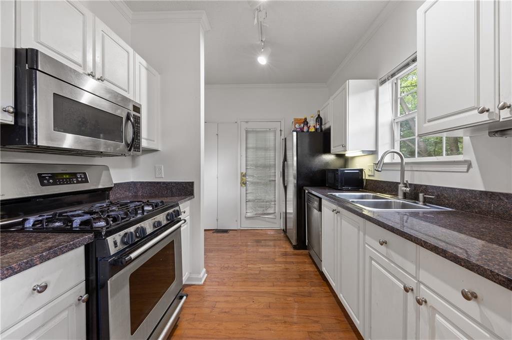 581 Cooper Street Southwest Atlanta, GA 30312 - Photo 10 of 26 a kitchen with stainless steel appliances granite countertop a stove microwave and sink