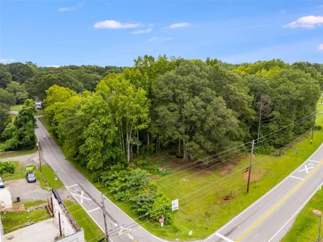 a view of a swimming pool with a garden and trees in the background