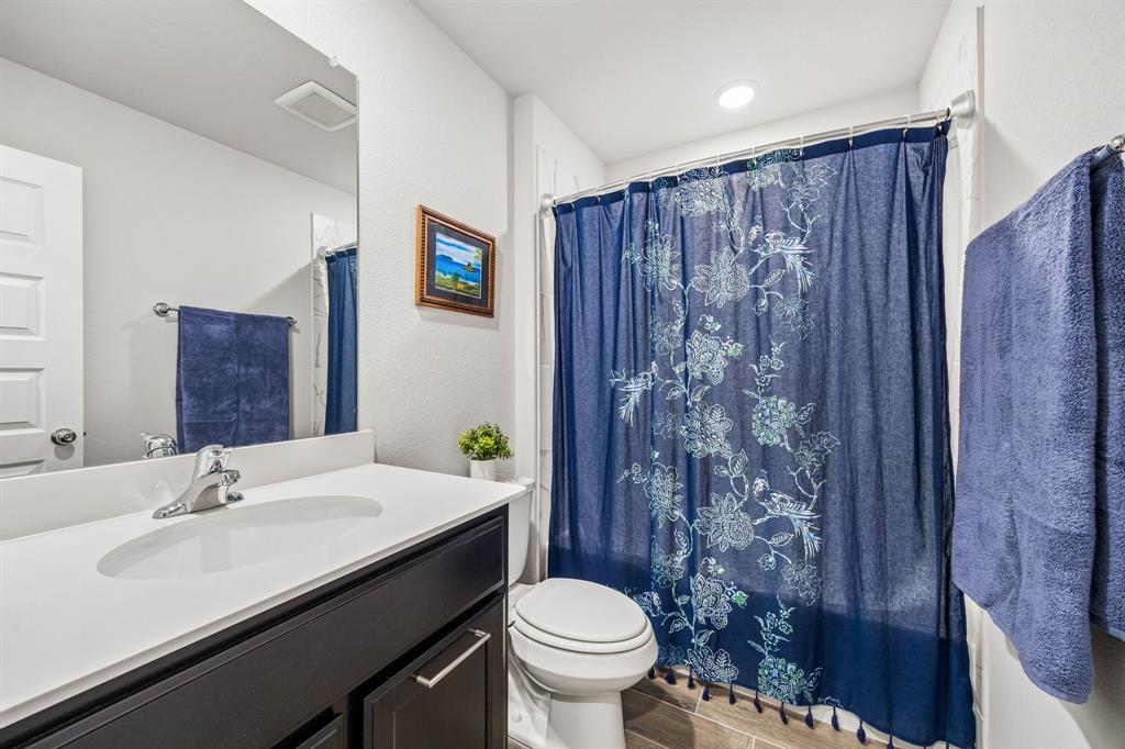 14061 Earlham Street Pilot Point, TX 76258 - Photo 5 of 10 a bathroom with a sink a toilet and shower curtain