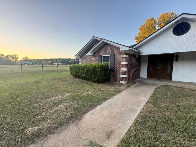a view of a house with a yard and a pond