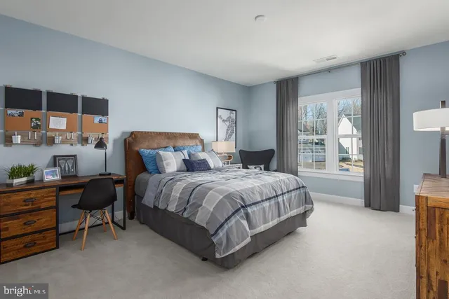 a spacious bedroom with a bed and a large window