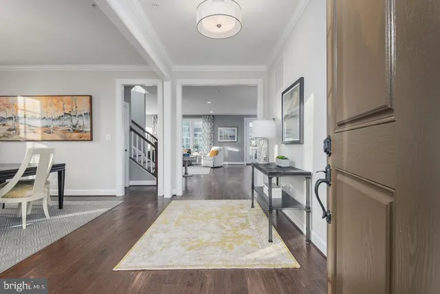 a living room with couches and a flat screen tv with wooden floor