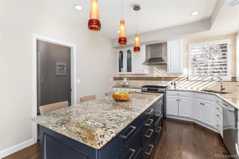 a kitchen with stainless steel appliances granite countertop a kitchen island a stove a table and chairs in it