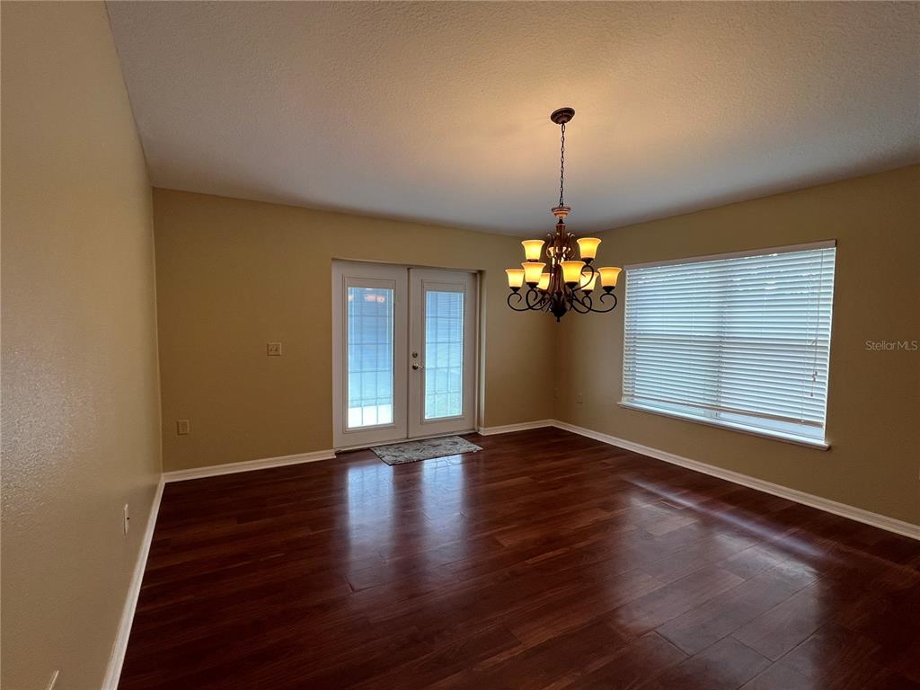 14367 Finsbury Drive Spring Hill, FL 34609 - Photo 12 of 35 a view of an empty room with window and wooden floor