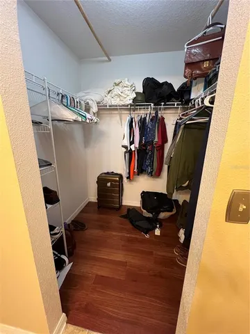 a view of walk in closet with clothes and shoes