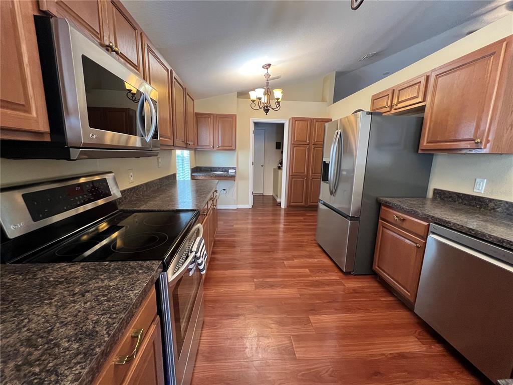 14367 Finsbury Drive Spring Hill, FL 34609 - Photo 2 of 35 a kitchen with granite countertop stainless steel appliances and wooden cabinets