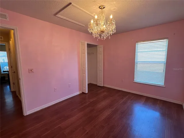 a view of a room with wooden floor and chandelier