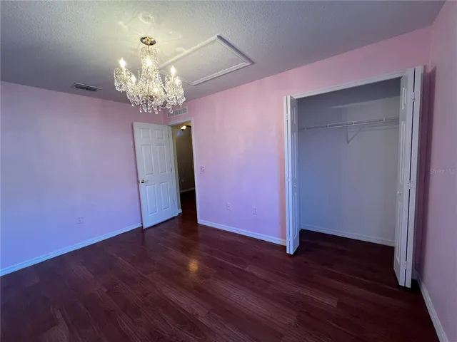 a view of a room with wooden floor chandelier and a window
