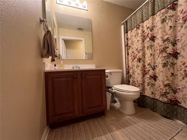 a bathroom with a toilet a sink and mirror