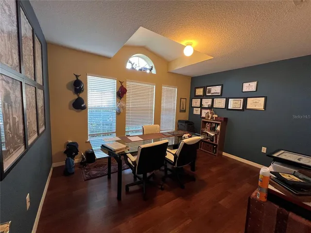 a view of a workspace with furniture and wooden floor
