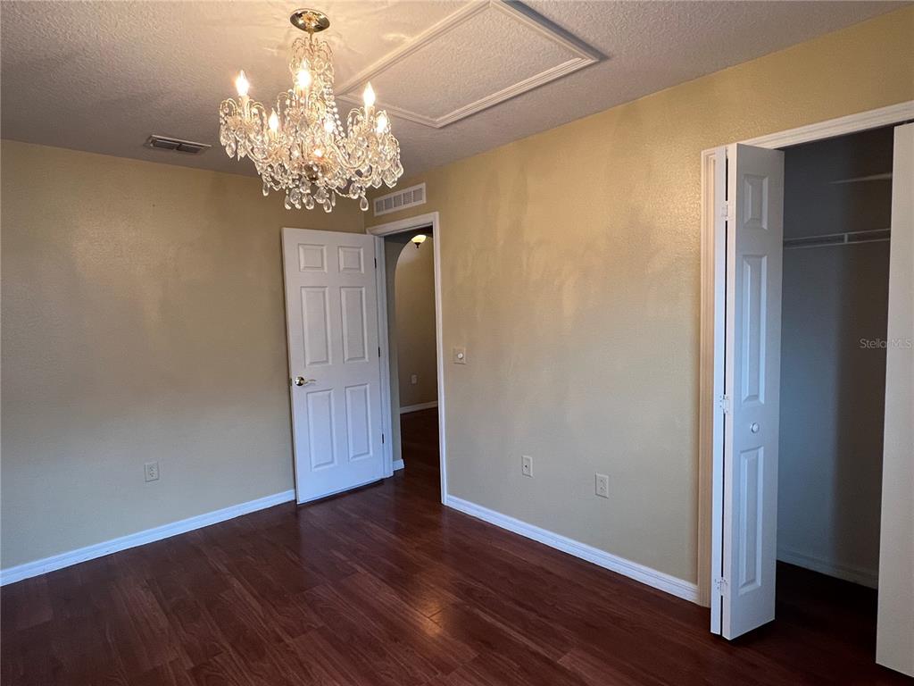 14367 Finsbury Drive Spring Hill, FL 34609 - Photo 30 of 35 a view of a chandelier in a room with wooden floor