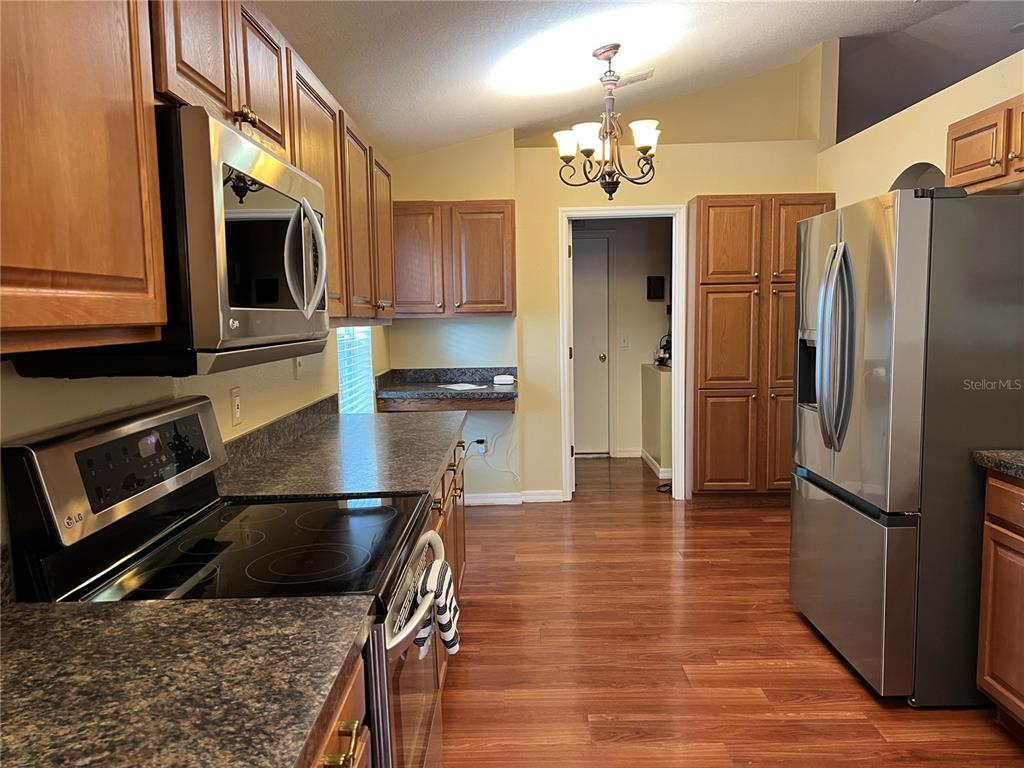 14367 Finsbury Drive Spring Hill, FL 34609 - Photo 4 of 35 a kitchen with stainless steel appliances granite countertop a refrigerator stove and microwave