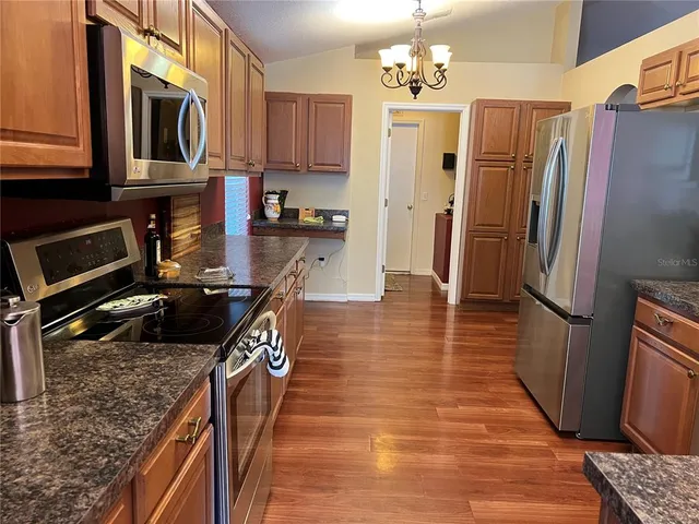 a kitchen with stainless steel appliances granite countertop a refrigerator a stove microwave and cabinets