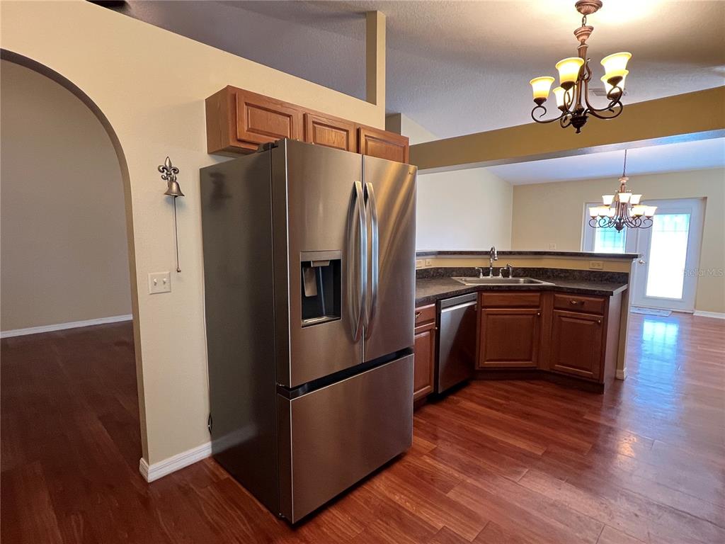 14367 Finsbury Drive Spring Hill, FL 34609 - Photo 6 of 35 a kitchen with stainless steel appliances granite countertop a refrigerator a stove and a wooden floors