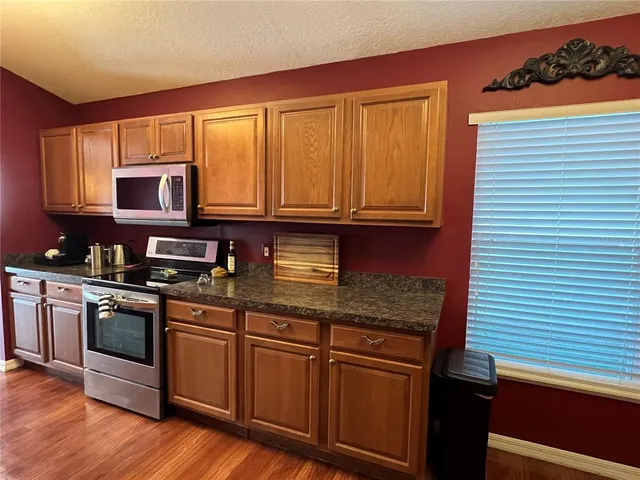 a kitchen with stainless steel appliances granite countertop wooden cabinets a stove top oven a sink and dishwasher