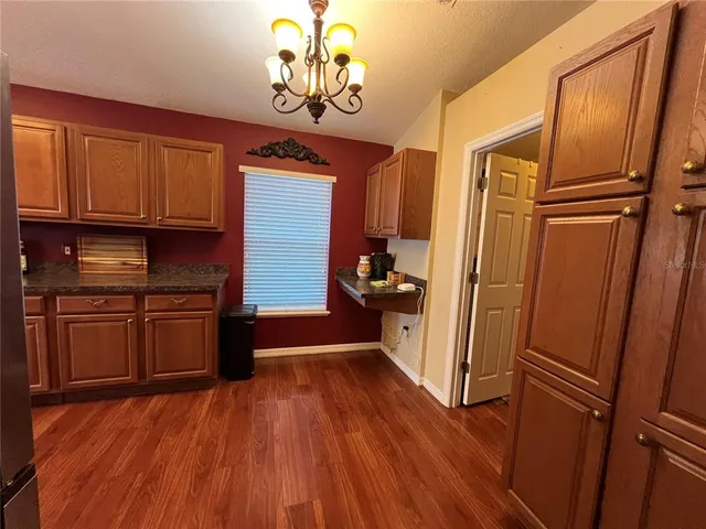 a kitchen with stainless steel appliances granite countertop a refrigerator a stove and a wooden floors