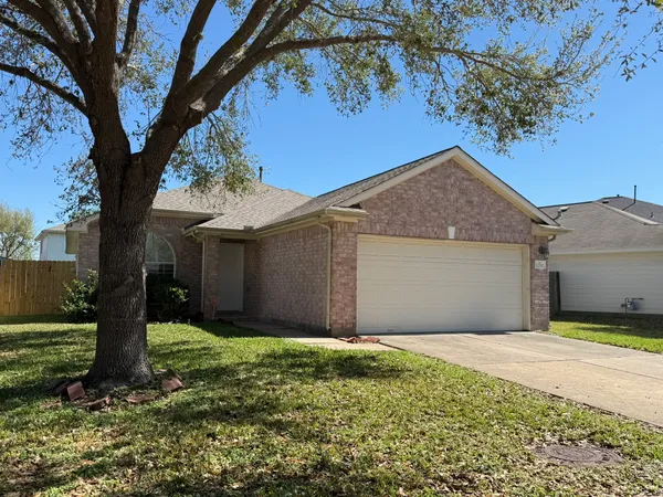 a front view of a house with a yard and tree