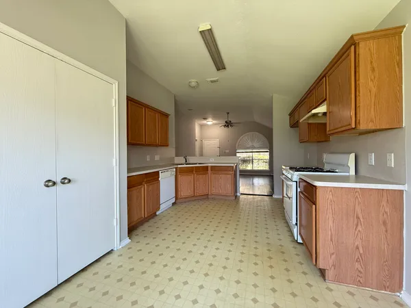 a kitchen with stainless steel appliances granite countertop a sink a stove and a refrigerator