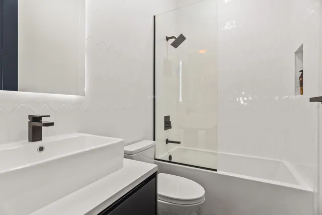 a bathroom with a sink a toilet and shower