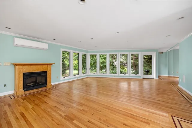 wooden floor fireplace and windows in an empty room