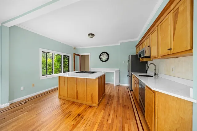 a view of a kitchen with a sink and wooden floor