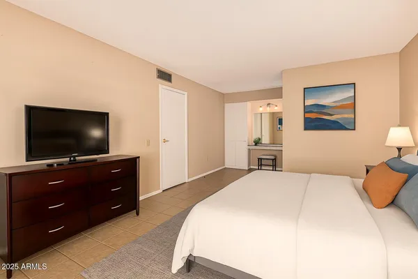 a bedroom with a bed and a flat screen tv