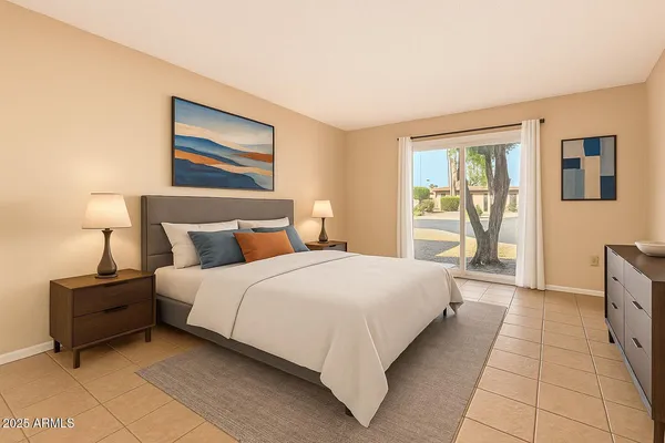 a bedroom with a bed painting on wall and a large window
