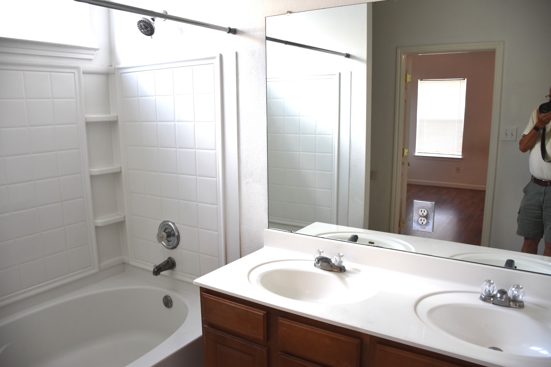 11300 Dimmit Street Manor, TX 78653 - Photo 12 of 23 Double vanity sinks and an integrated shower-tub combo create a functional bathroom space.