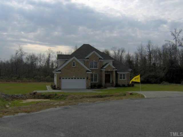 a view of a big house with a big yard and large trees