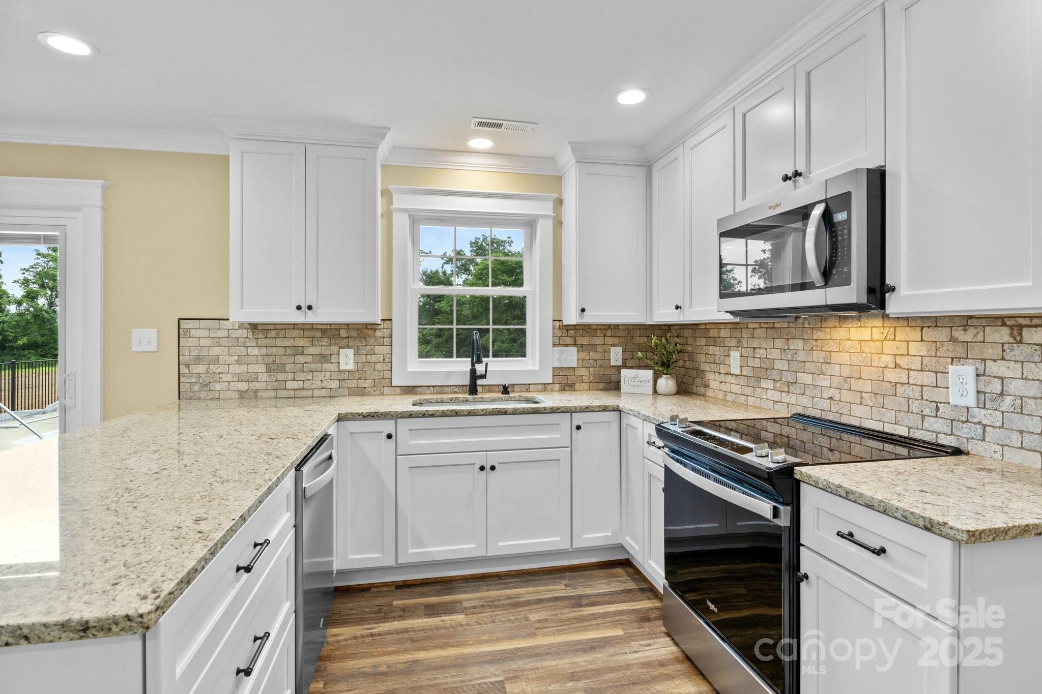 893 Chief Thomas Road Harmony, NC 28634 - Photo 11 of 38 a kitchen with stainless steel appliances granite countertop a sink stove and microwave