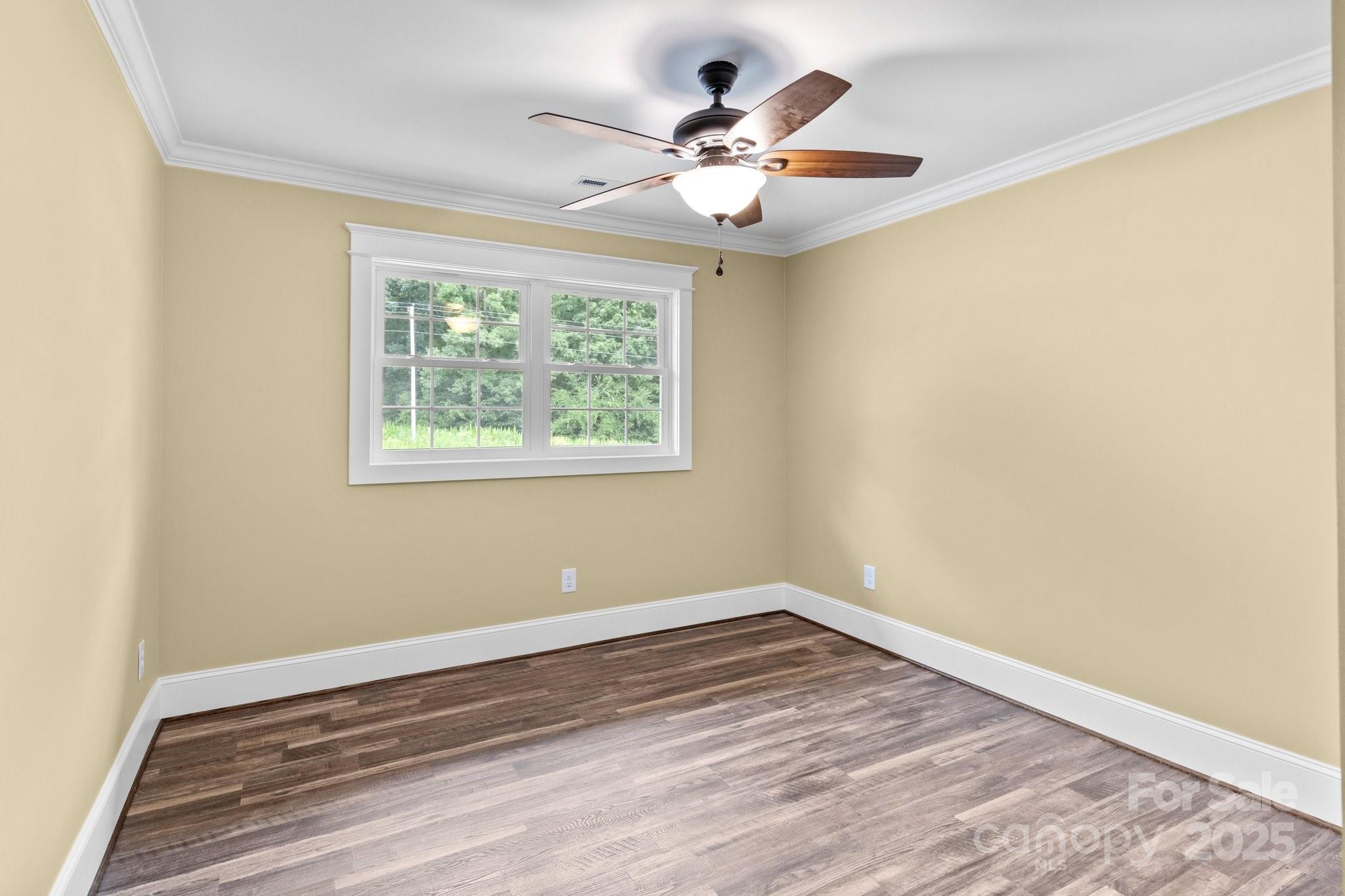 893 Chief Thomas Road Harmony, NC 28634 - Photo 18 of 38 a view of a room with wooden floor and a ceiling fan
