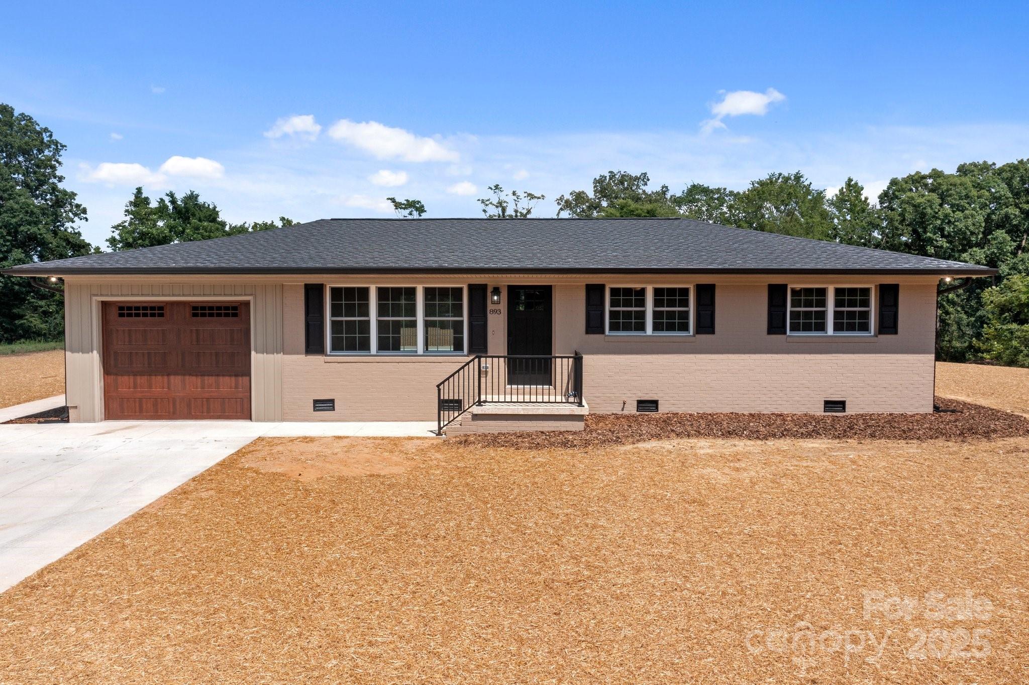 893 Chief Thomas Road Harmony, NC 28634 - Photo 2 of 38 a front view of a house with a yard and garage