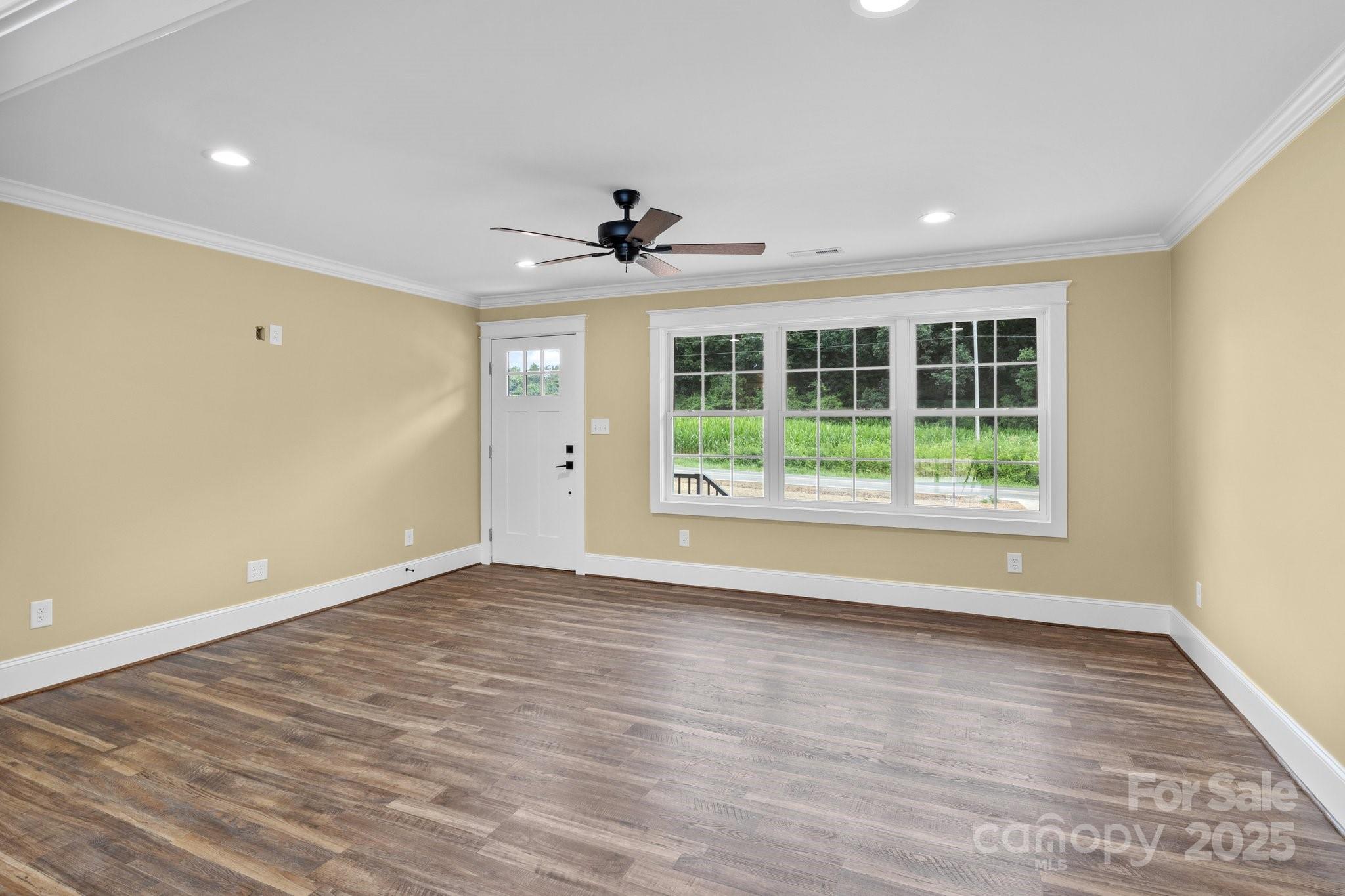 893 Chief Thomas Road Harmony, NC 28634 - Photo 5 of 38 a view of an empty room with wooden floor and a window