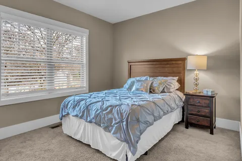 a bedroom with a bed and a large window