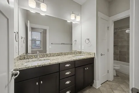 a bathroom with a granite countertop sink a large mirror and a shower