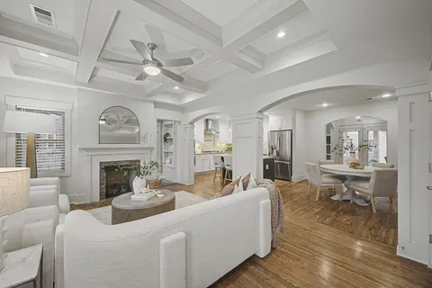 a living room with furniture a fireplace and a ceiling fan