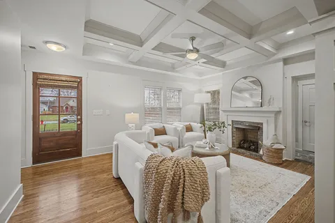 a living room with furniture fireplace and wooden floor