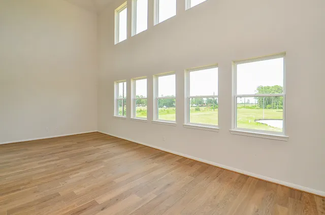 a large white kitchen with stainless steel appliances granite countertop a sink and dishwasher a stove with wooden floors