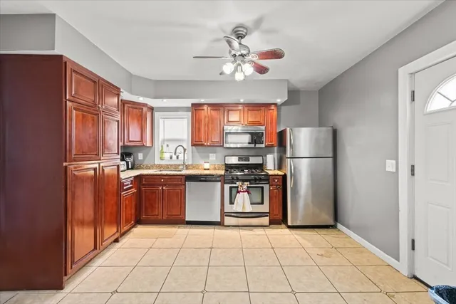 a kitchen with stainless steel appliances granite countertop a refrigerator a sink dishwasher a stove with wooden cabinets and floor